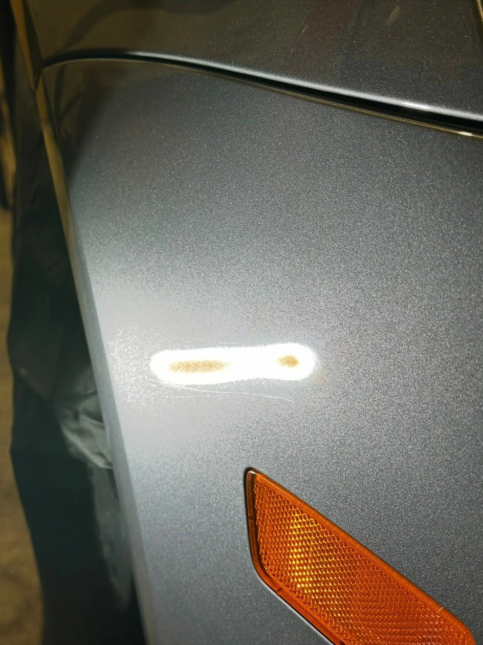 Avant : micro-rayures révélées à la lampe sur l’aile avant d’une Volkswagen Golf 5 R32 grise