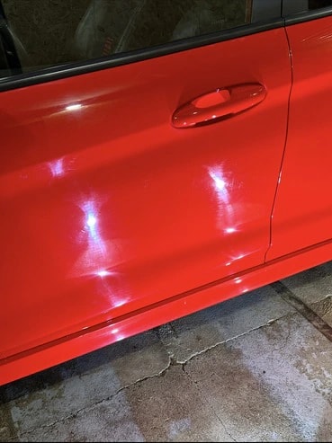 Avant : défauts révélés par l’éclairage de l’atelier sur la porte avant gauche d’une Ford Fiesta ST Line