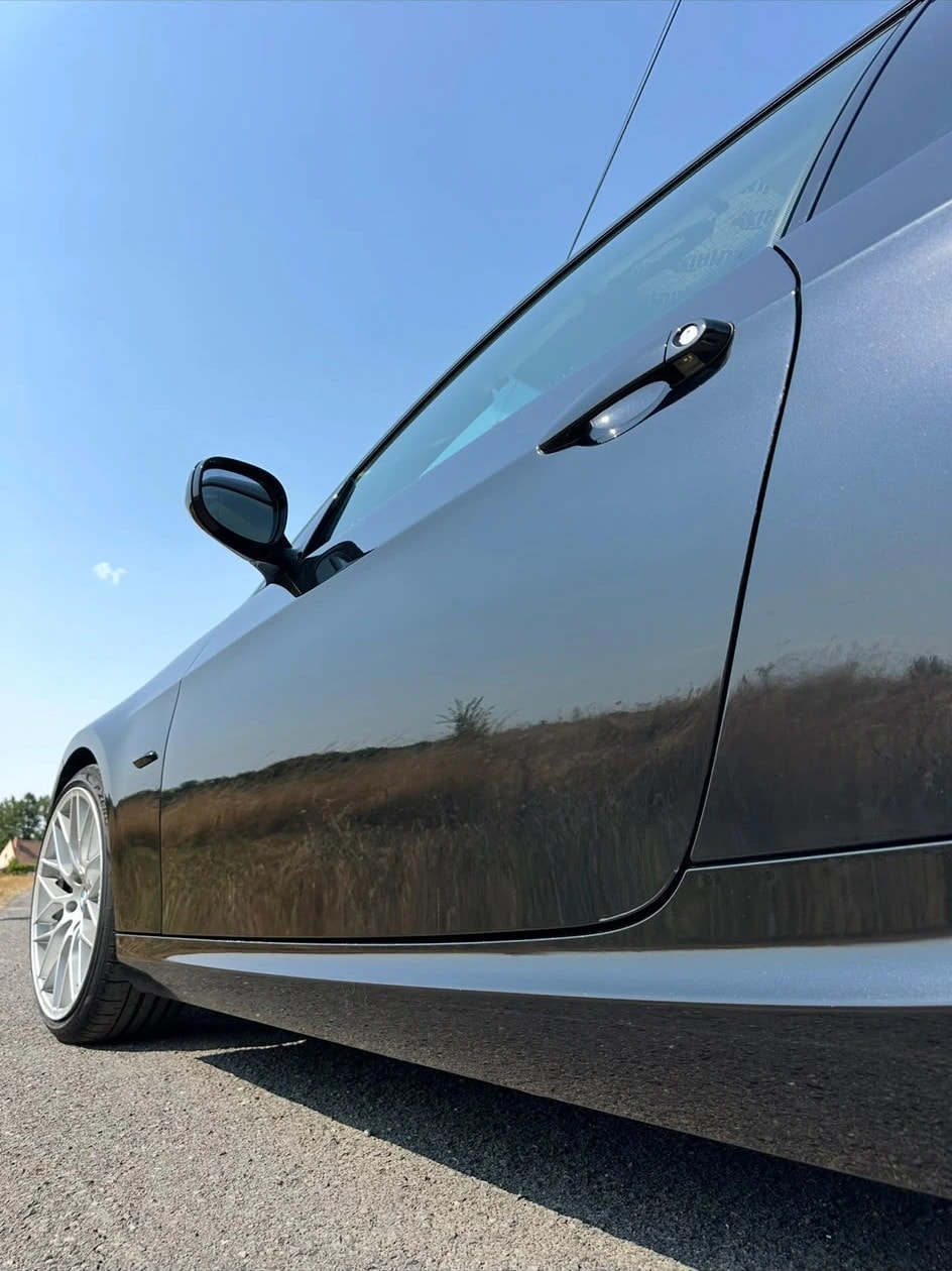 BMW Série 3 Coupé gris foncé polie, flanc en plein soleil